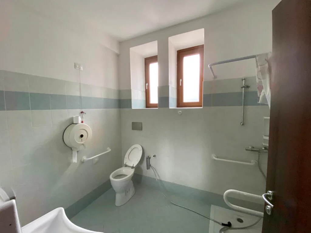 Bagno attrezzato accessibile con maniglioni e doccia a pavimento