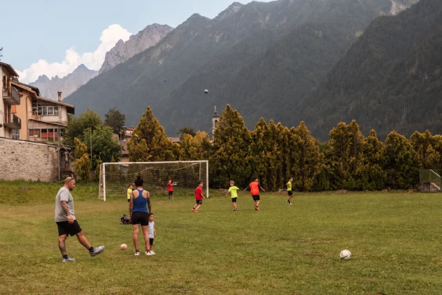 Ragazzi sul campo da calcio con le montagne